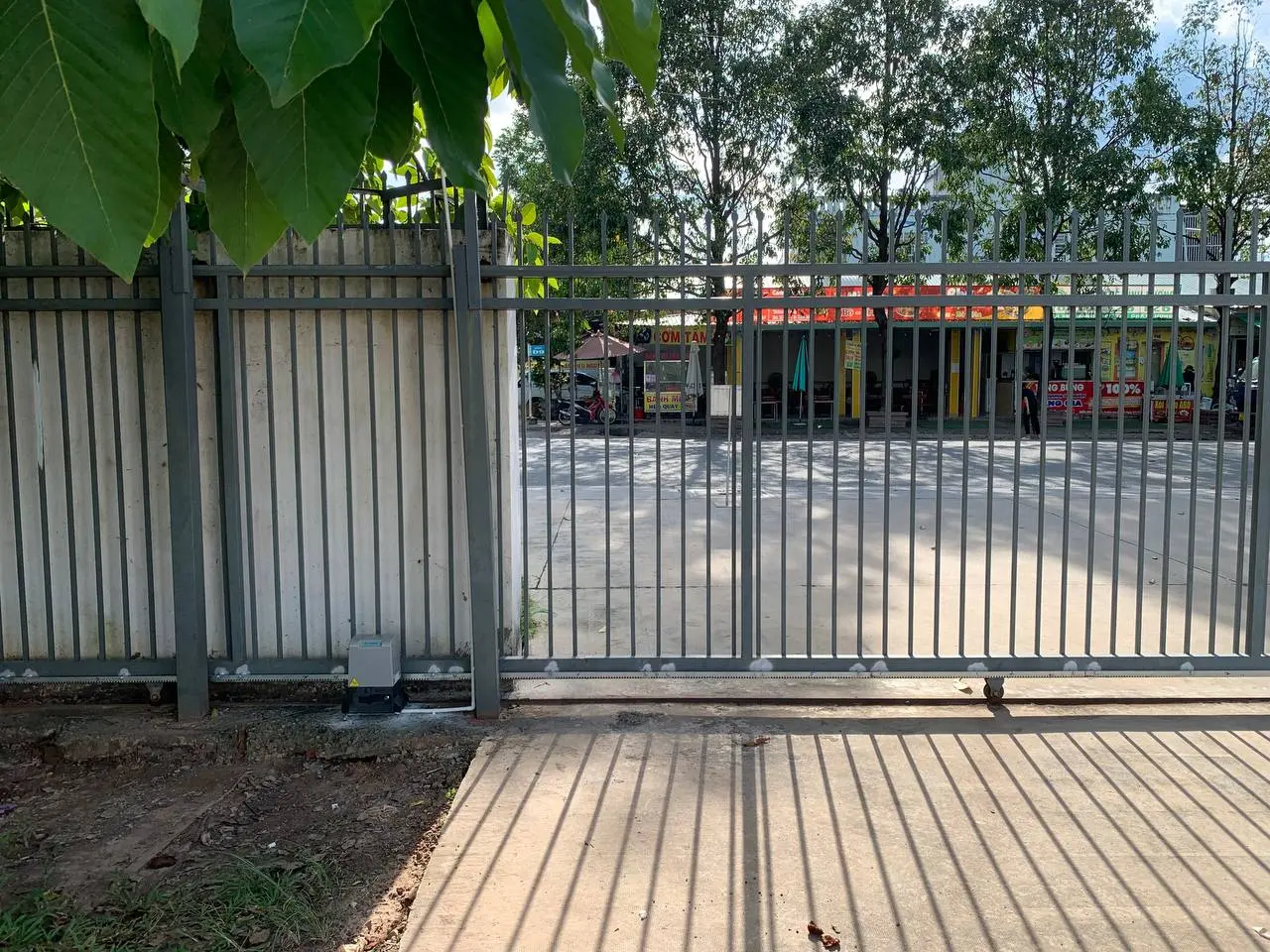 Portón corredera automatizado con motor y cremallera visibles